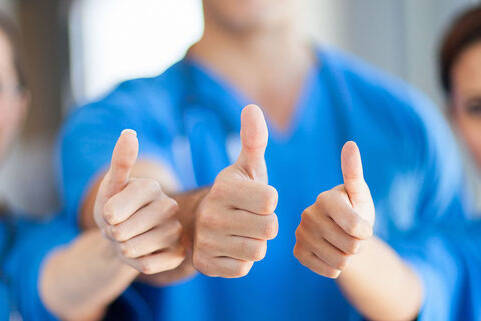 Pflegekräfte zeigen den Daumen nach oben